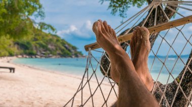Erkekler ayakları hamakta Haad Rin, Ko Phangan sahilde rahatlatıcı