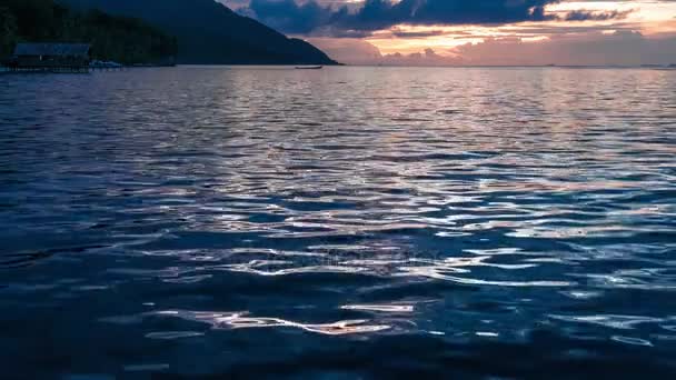 Puesta de sol sobre Kri y Monsuar, Ondas de calma moviéndose sobre la superficie del océano, Papúa Occidental, Raja Ampat, Indonesia — Vídeos de Stock
