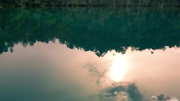 Solen spegelbild i vattenytan framför Gam Island på väg till dolda bay, över Passage, Raja Ampat, västra Papua, Indonesien — Stockvideo