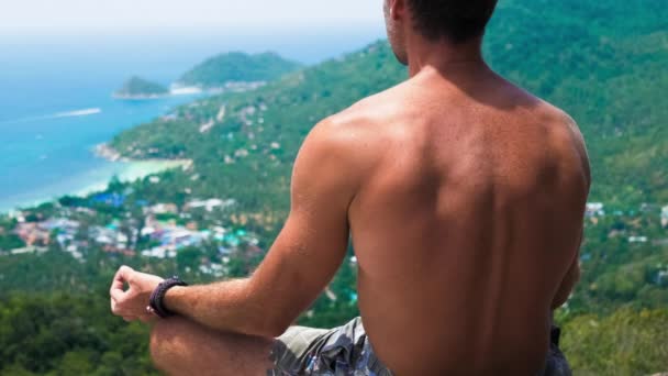 Gli uomini meditano sulla cima di un punto di vista in direzione di Sairee Beach e Nang Yuan Island sullo sfondo — Video Stock