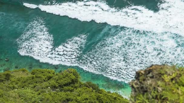 Blick von oben auf Wellen, die einen nach dem anderen zum Nunggalan-Strand rollen, uluwatu, bali, Indonesien — Stockvideo