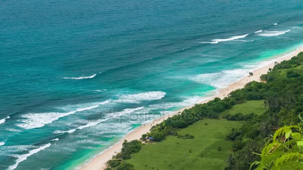 Toeristen die aankomen naar eenzame zandstrand op Uluwatu kustlijn, Bali, Indonesië — Stockvideo