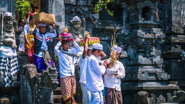 GOA LAWAH, BALI, INDONESIA - November 3, 2016: Balinese people in traditional clothes carry bless gift after ceremony at Pura Goa Lawah temple, Bali, Indonesia — Stock Photo, Image