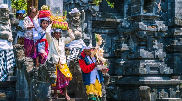 GOA LAWAH, BALI, INDONESIA - November 3, 2016: Balinese people in traditional clothes carry bless gift after ceremony at Pura Goa Lawah temple, Bali, Indonesia — Stock Photo, Image