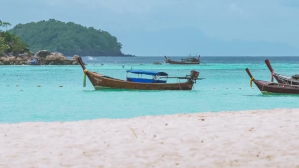 Bateaux à longue queue balançant dans l'eau bleue avec plage de sable blanc devant en attendant le touriste, île de Koh Lipe, Thaïlande — Video