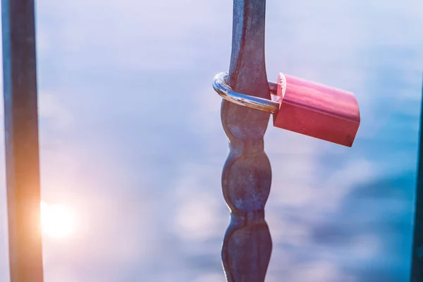 하나의 사랑 잠금 또는 태양 반사 발 적으로 호수 앞 사랑의 자물쇠. 클로즈업 — 스톡 사진