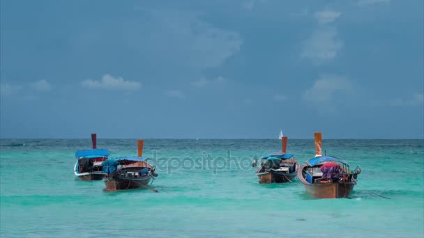 Fire langhalede båter svingende i blå bølger, hvit seilbåt i horisonten, Koh Lipe Thailand – stockvideo