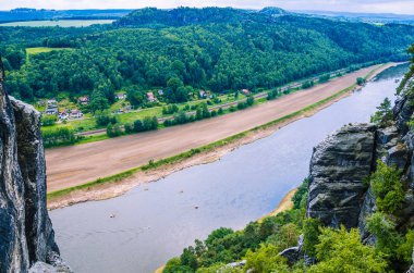 Elbe Nehri ile küçük köyün önünde Bastei kumtaşı kaya Sakson İsviçre, Dresden, Almanya
