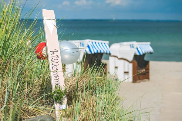 Cadeiras cobertas de cor azul na praia de areia em Travemunde, Alemanha. Balões de boas-vindas — Fotografia de Stock