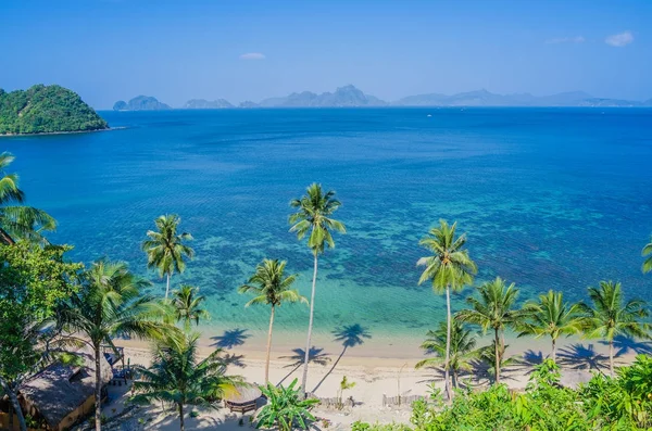 Playa de arena con sombras de palma, enormes rocas en el fondo, El Nido, Palawan, Filipinas — Foto de Stock