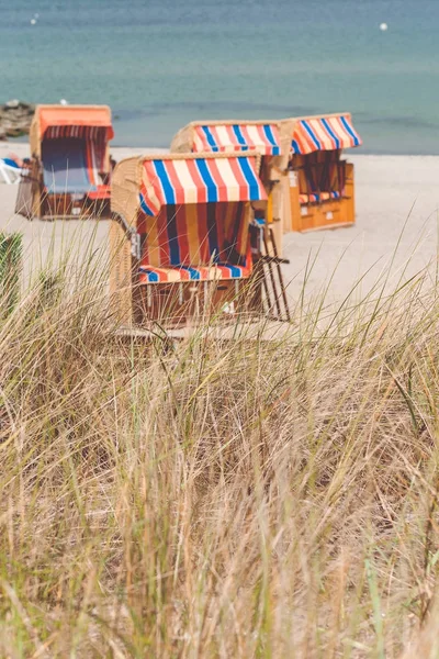 Cadeiras de telhado listradas coloridas na praia de areia em Travemunde., Lubeck, Alemanha — Fotografia de Stock