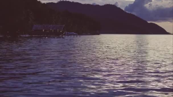 Alloggio in famiglia su Kri e Monsuar al tramonto. Onde calme che brillano sulla superficie dell'oceano, Papua occidentale, Raja Ampat, Indonesia — Video Stock