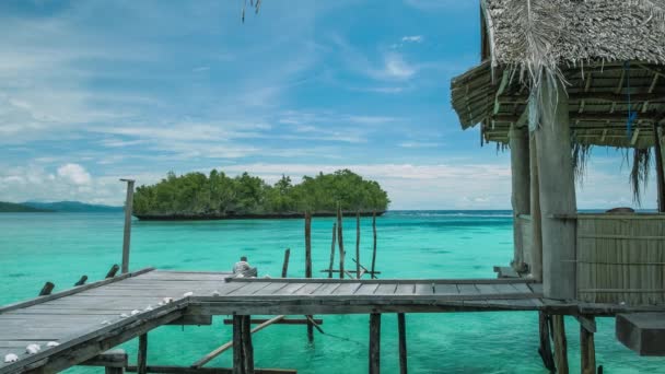 Homstay καλύβα στην όμορφη μπλε lagoone και ορισμένες νησιωτικές στο παρασκήνιο. Kordiris Homestay σε Gam νησιού, Δυτική Παπούα, Raja Ampat, Ινδονησία — Αρχείο Βίντεο