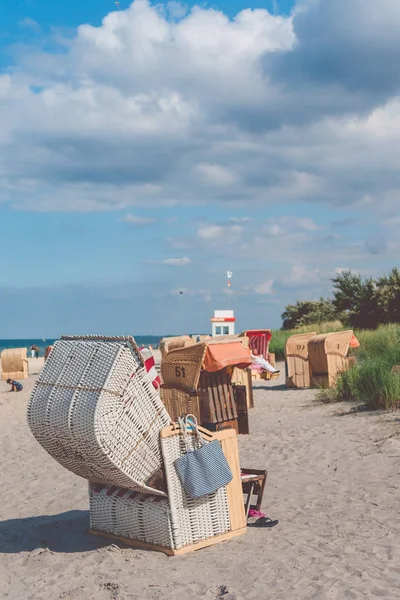 Turistické odpočívá relaxovat v pruhované zastřešená židle na písečné pláži v Travemunde., Lübeck, Německo — Stock fotografie