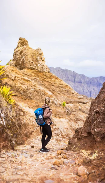 Caminhante mulher na trilha pedregosa de trekking em frente ao pico estéril da montanha na ilha de Santo Antão, Cabo Verde — Fotografia de Stock