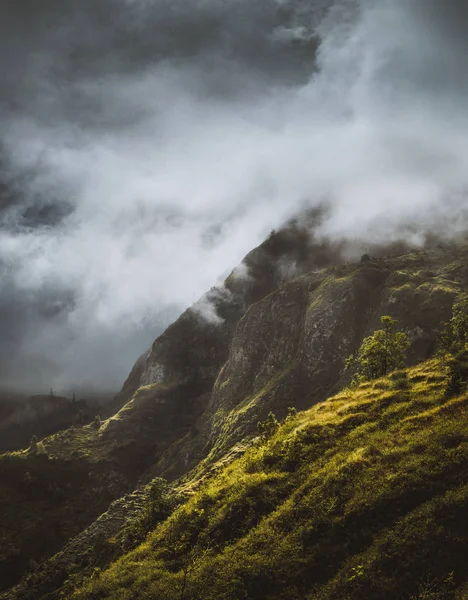 Потрясающий пейзаж с туманом, текущим по огромному горному склону и выливающимся в зеленую долину. Санто-Антао-Кабо-Верде-Кабо-Верде — стоковое фото