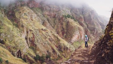 Etkileyici dağ yüz hayran erkek uzun yürüyüşe çıkan kimse ünlü Paul Vadisi dik kayalık yolda. Santo Antao Cape Verde Cabo Verde