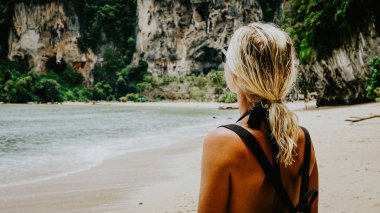 Sarışın güzel kadın güneş gözlüğü ve şapka Tom Sai Beach, Railay, Krabi kurabiyelerimi, sırt ile