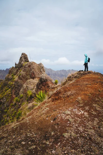 Путешественник с рюкзаком, смотрящим на горные вершины. Ландшафт острова Санто-Антао, Кабо-Верде — стоковое фото