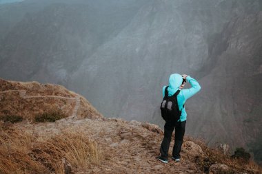Yüksek irtifa kayalık dağ manzarası önünde bir derin Uçurumu'nun adam. Santo Antao Cape Verde trekking iz