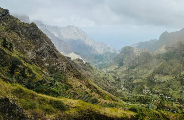 Gorgeous panorama view of a fertile Paul valley. Agriculture terraces in vertical valley sides, rugged peaks and motion clouds on horizon — Stock Photo, Image