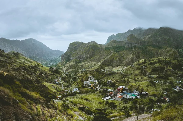 Gorgeous panorama view of a fertile Paul valley. Agriculture terraces of sugarcane in vertical valley sides, dwellings, rugged peaks and motion clouds on horizon — Stock Photo, Image