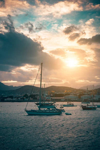 Navega en barco anclado en el puerto de Mindelo al atardecer. Las bengalas doradas iluminan el cielo nublado. Isla de Sao Vicente, Cabo Verde — Foto de Stock