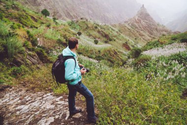 Santo Antao. Cape Verde. Yalnız Arnavut kaldırımlı trekking iz büyük rock ile yeşil vadiye doğru yürürken fotoğrafı.