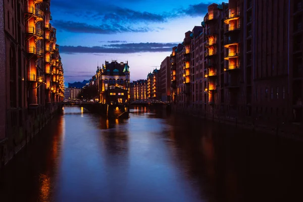 Blue hour in Warehouse District Speicherstadt (en inglés). Monumento turístico de Hamburgo en el crepúsculo. Vista de Wandrahmsfleet en lámpara de luz de linterna. Place se encuentra en Puerto de Hamburgo, en el barrio de HafenCity — Foto de Stock