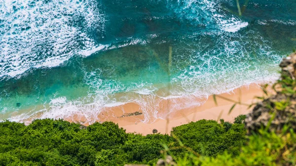 Luftaufnahme von rein klaren türkisfarbenen Wellen, die an einem sonnigen Tag am tropischen Sandstrand rollen, umgeben von Dschungel — Stockfoto