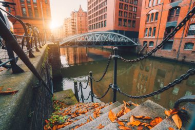 Speicherstadt, Almanya 'da Hamburg eyaletinde yer alan bir şehirdir. Eski tuğla binalar ve Hafencity Kanalı Sonbahar akşamında gün batımında altın alevler