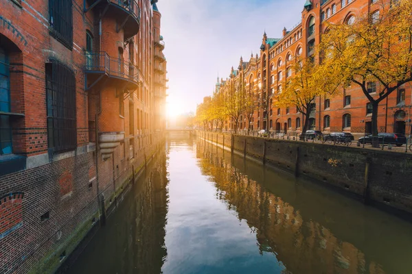 Dzielnica magazynowa Speicherstadt w Hamburgu, Niemcy. Jesienna pogoda. Stare murowane budynki, kanał rzeczny dzielnicy Hafencity z zachodem słońca złote flary i odbicia wody — Zdjęcie stockowe