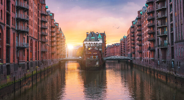 Старый порт Гамбурга, Германия, Европа. Исторически известный складской район с дворцом водяного замка на закате золотой свет. Панорамная сцена
