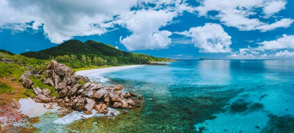 Vue panoramique aérienne de l'impressionnante plage de Grand Anse sur l'île de La Digue aux Seychelles. Rochers de granit et lagune océanique turquoise avec nuages blancs au-dessus — Photo