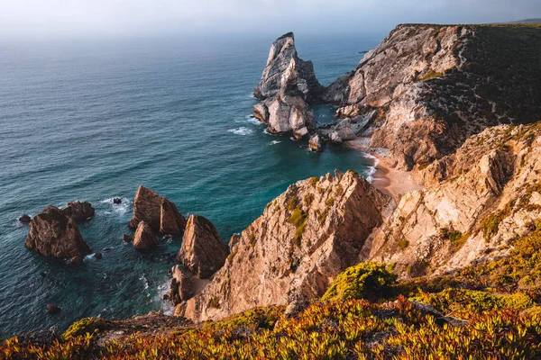 프라 이아 다 우르 사 해변에 는 석양 빛을 받아 정면에 바위들이 있었다. 포르투갈, 시트라의 초현실적 인 풍경. 대서양 해안선 풍경 — 스톡 사진