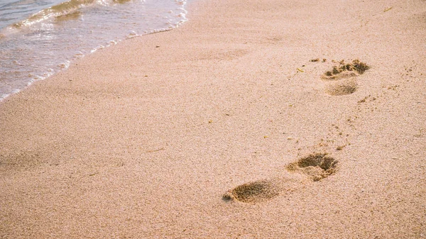 Wave and footprints on clear sandy beach. — 스톡 사진