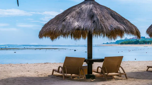 Koncepcja wakacji. Dwa leżaki i parasol palmowy sunshirm na plaży oceanu piasku. — Zdjęcie stockowe