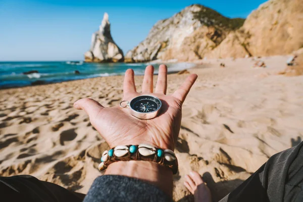 Bússola na mão aberta simbolizando o conceito de busca de aventura contra a praia de Ursa, Sintra, Portugal — Fotografia de Stock
