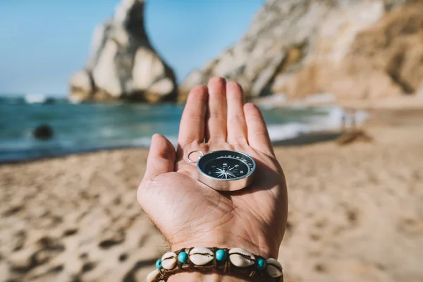 Mão de homem com bússola simbolizando conceito de busca de aventura contra a praia de Ursa, Sintra, Portugal — Fotografia de Stock