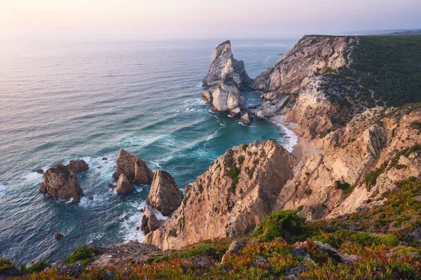 Sintra, Portugalsko. Praia da Ursa nebo Ursa Beach působivé jedinečné mořské komíny a útesy ve večerním západu slunce na pobřeží Atlantského oceánu — Stock fotografie