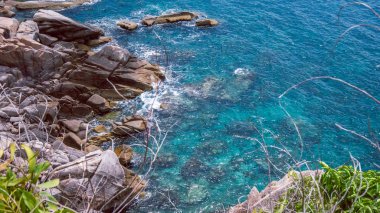 Tayland 'daki Koh Tao adaları. Mavi berrak su kayalara çarpar