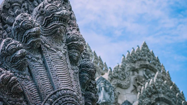 Skulptur of many snake heads. Shape of ancient stone temple in background — Stock Photo, Image