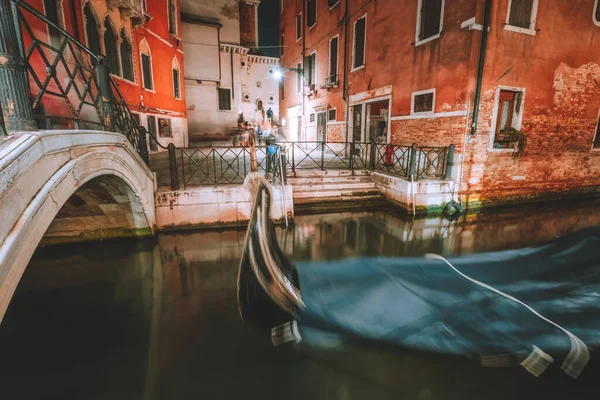 Venice Gondola boat in small channel with arch bridge in lagoon city Venice at night time. long exposure Venezia Italy — Stock Photo, Image