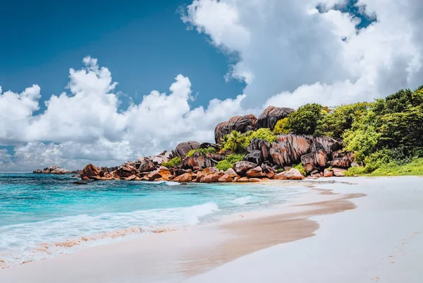 Plaża tropikalna Grand Anse na Seszelach. Słynne granitowe formacje skalne i białe chmury nad nami — Zdjęcie stockowe