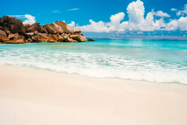 Spiaggia Grand Anse all'isola di La Digue alle Seychelles. Spiaggia di sabbia con baia blu oceano, nuvole bianche sullo sfondo — Foto Stock