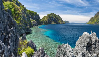 El Nido, Palawan, Filipinler. Taputan boğazı turist tekneleriyle dolu. Bacuit Takımadası 'ndaki Matinloc adasından görüntü