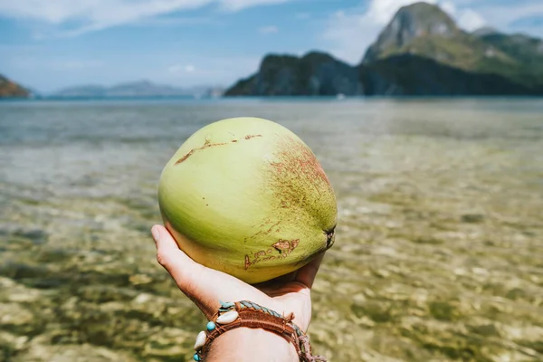 Encerramento de coco em mãos masculinas contra ilhas oceânicas exóticas — Fotografia de Stock