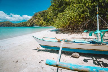 Geleneksel banka balıkçıları, kumlu uzak tropikal sahillerde tekne kullanırlar. El Nido, Filipinler