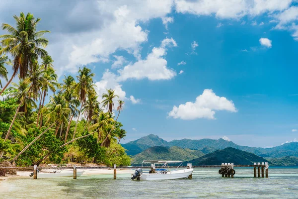 Krásná tropická scenérie pláž s palmami, molo, turistický člun a bílé mraky nad. Rekreační a ráj ostrov dovolená koncept — Stock fotografie
