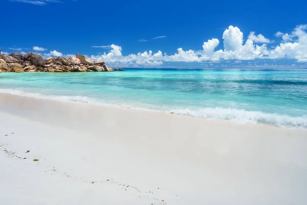 Spiaggia Grand Anse all'isola di La Digue alle Seychelles. Spiaggia di sabbia con bassa baia blu oceano, nuvole bianche sullo sfondo — Foto Stock